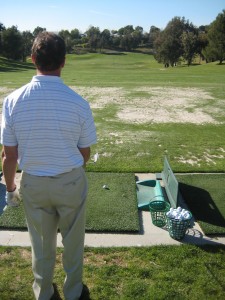 golfer begining process to his pre-shot routine on the driving range